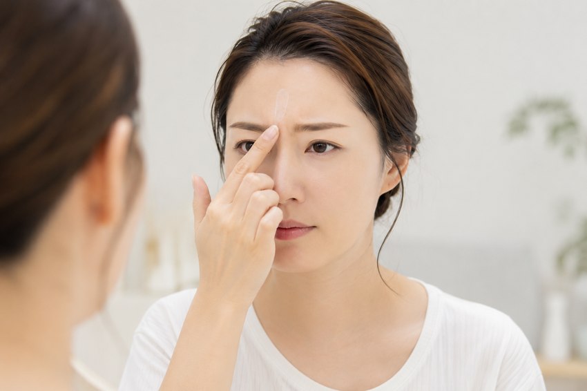 リンクルショット メディカル セラムを眉間の定着ジワに指先でなじませている様子